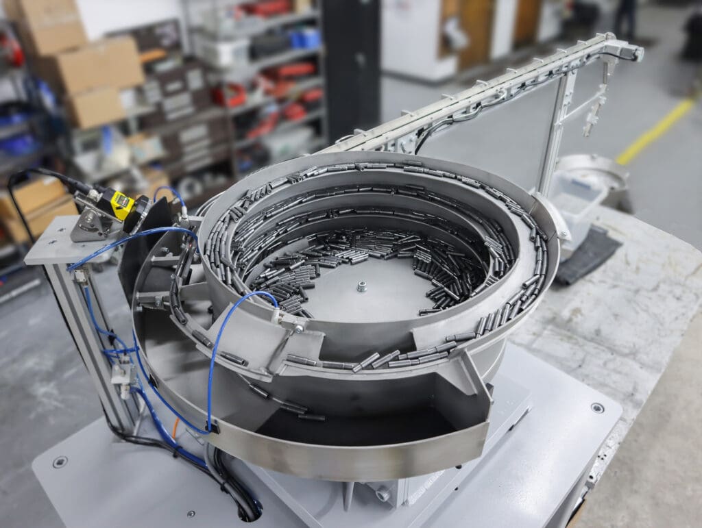 Vibratory bowl orients bolt blanks into a horizontal position with the small end leading.